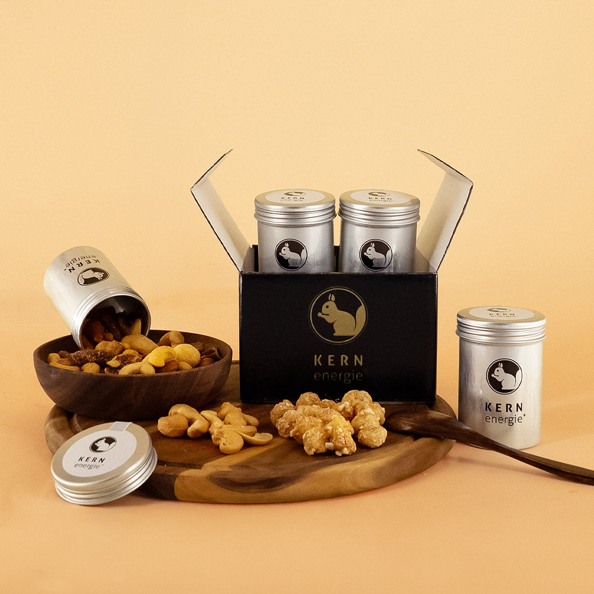 Geschenkset mit vier Aludosen und verschiedenen Nüssen auf Holztablett