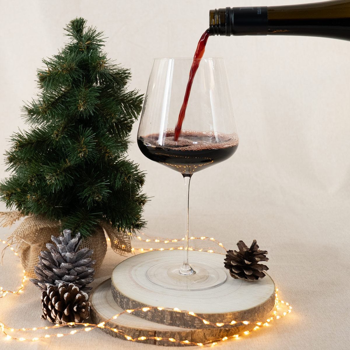 Rotwein in Weinglas mit weihnachtlicher Deko