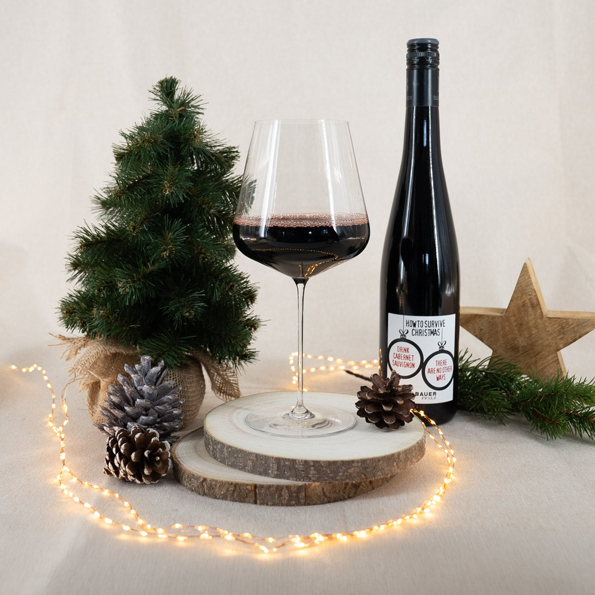 Rotwein "christmas Surviving" in Weinglas und mit weihnachtlicher Deko