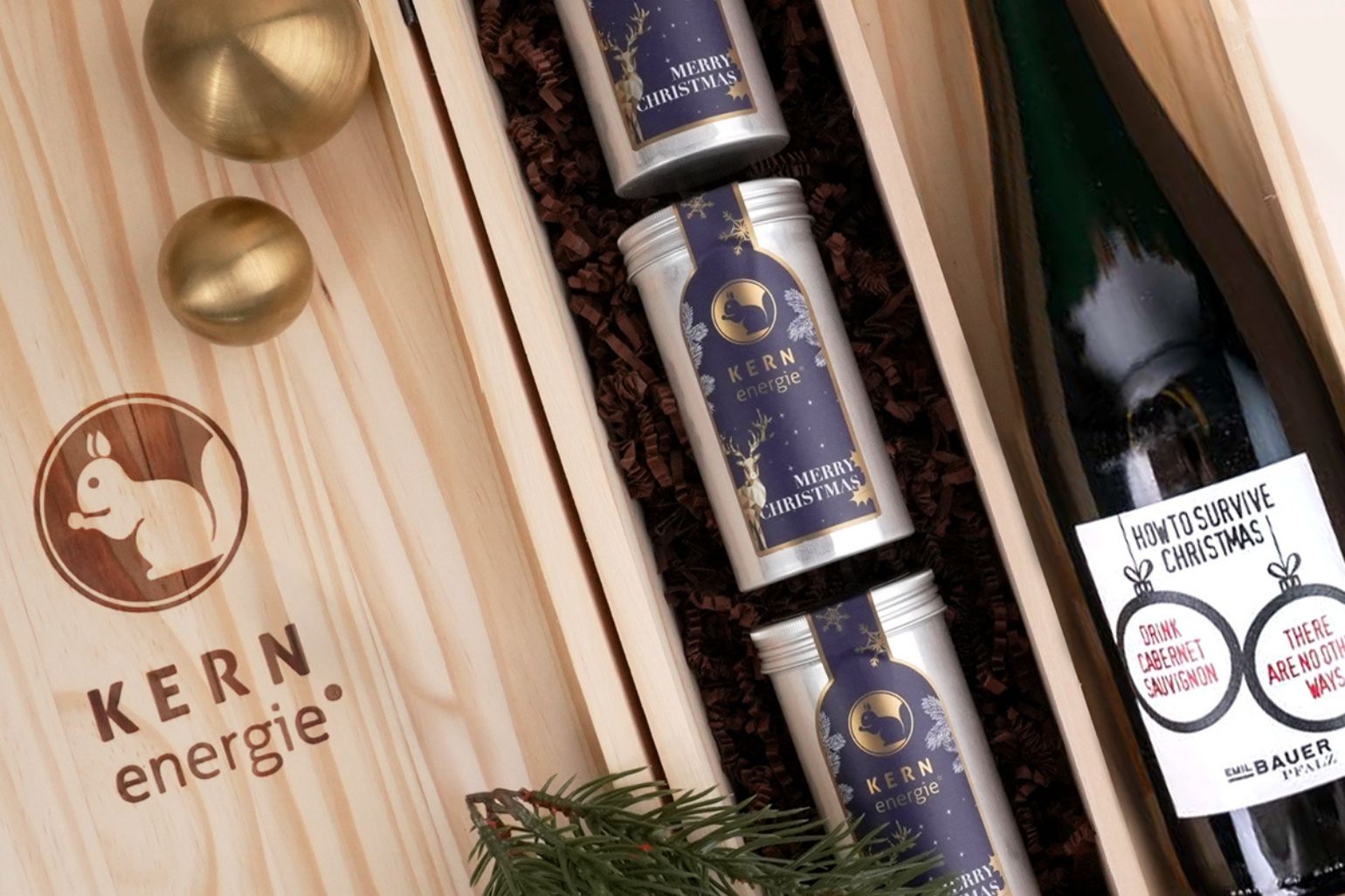 Holzbox mit Logo als exklusives Firmengeschenk zu Weihnachten – gefüllt mit Wein und Aludosen voller frisch gerösteter Nüsse mit festlichem Etikett.