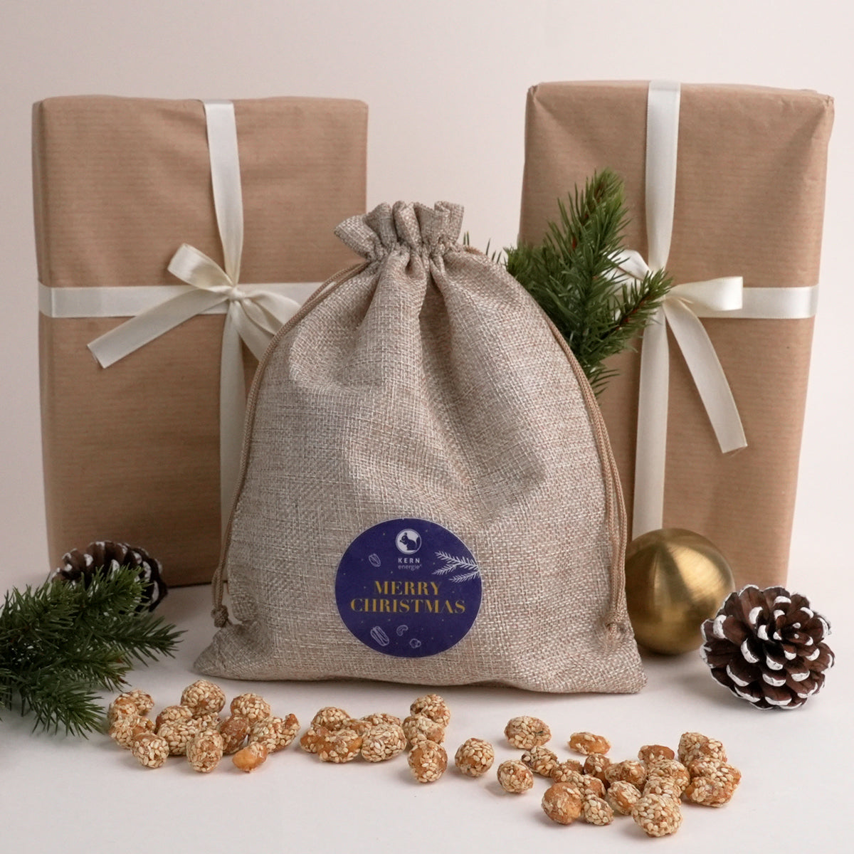 Nikolausgeschenk für Mitarbeiter – festlich verpacktes Sackerl mit 12×25 g Flowpacks frisch gerösteter Nüsse von KERNenergie als Mitarbeitergeschenk.