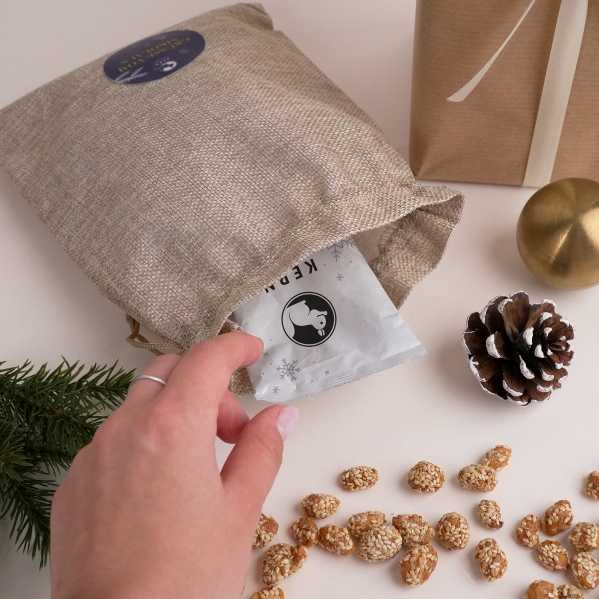 Mitarbeiter öffnet ein Stoffsäckchen als Werbeartikel und Firmengeschenk – gefüllt mit Nusstütchen von KERNenergie