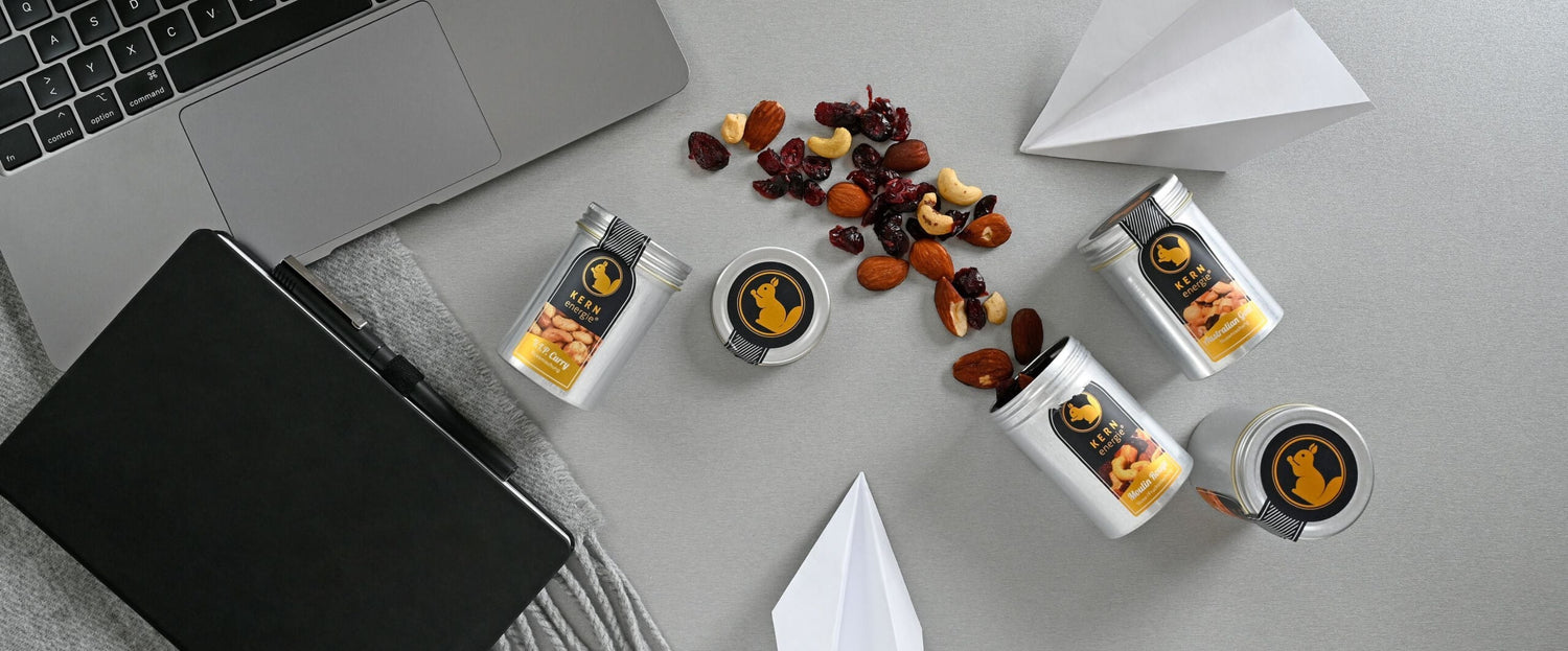 frisch geröstete KERNenergie in der Aluminiumdose als Brainfood neben Macbook und Terminplaner