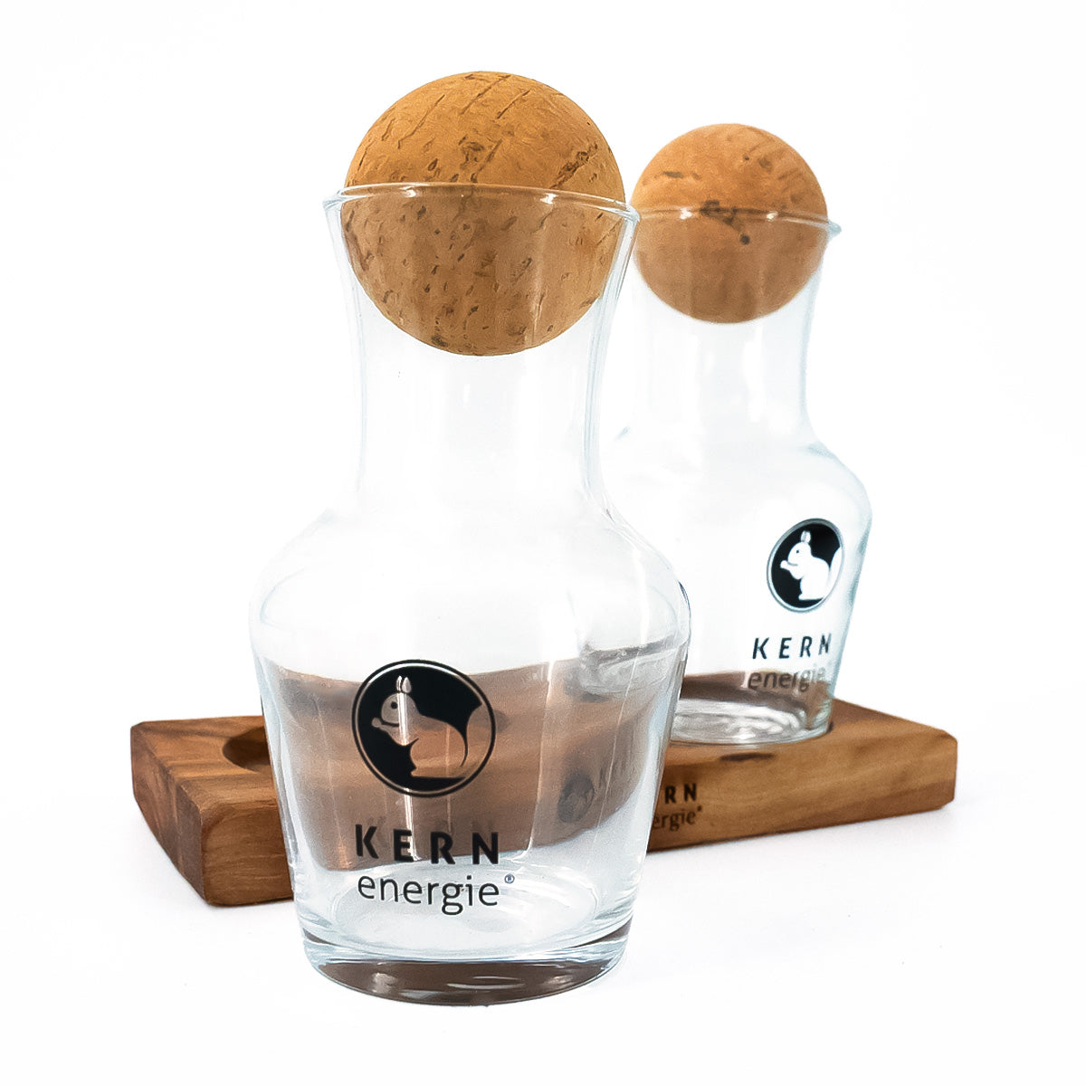 Nahaufnahme eines leeren Glas-Dekanters mit Holz-Korken und Logo von KERNenergie.