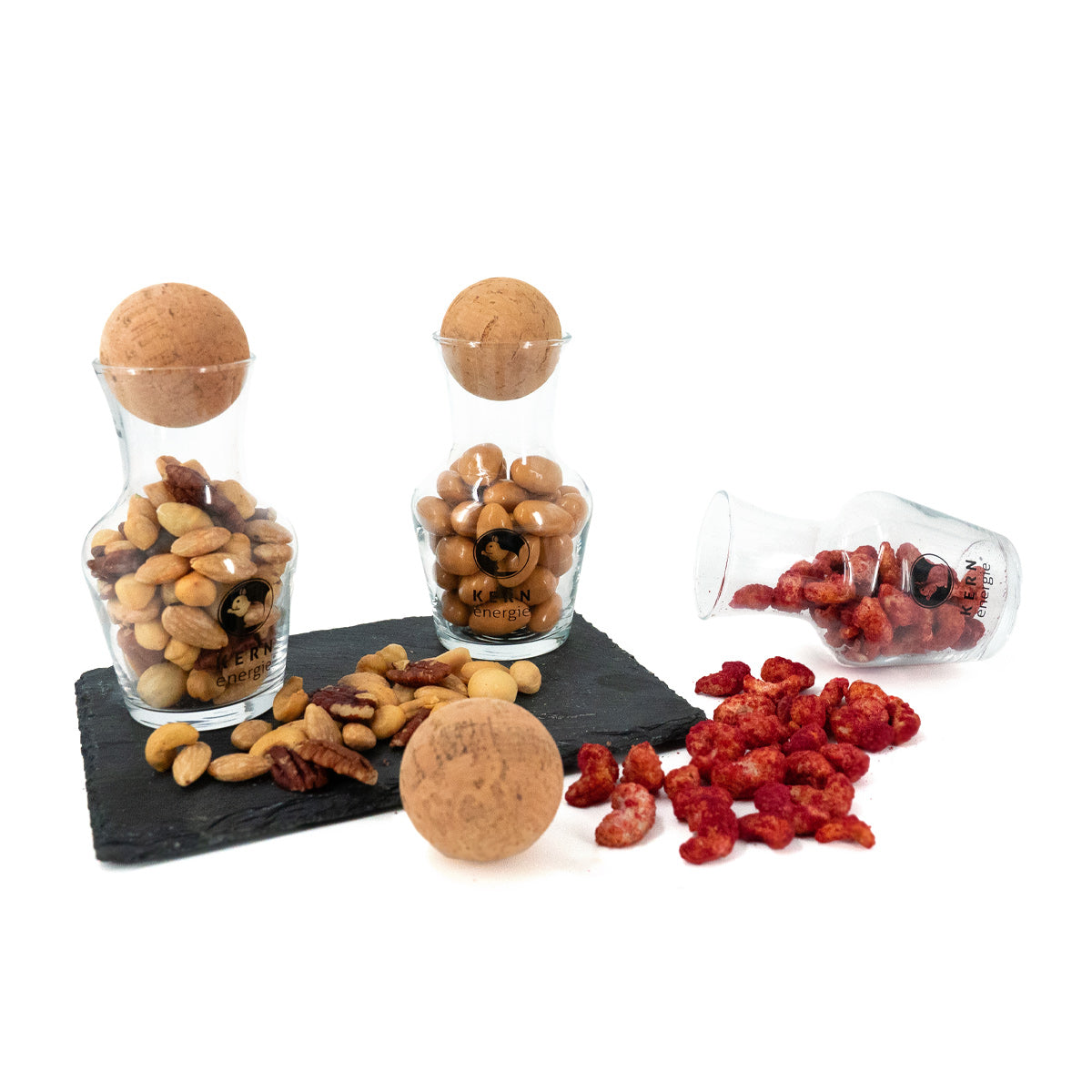 Dekanter-Set auf Schieferplatte mit verstreuten Nüssen und Nussmischungen, KERNenergie Servierset.