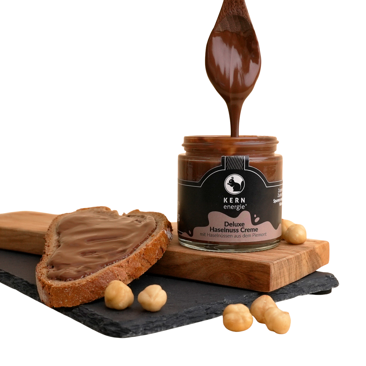 Stimmungsbild der Deluxe Haselnuss Creme mit Creme auf einem Löffel und auf einem Brot