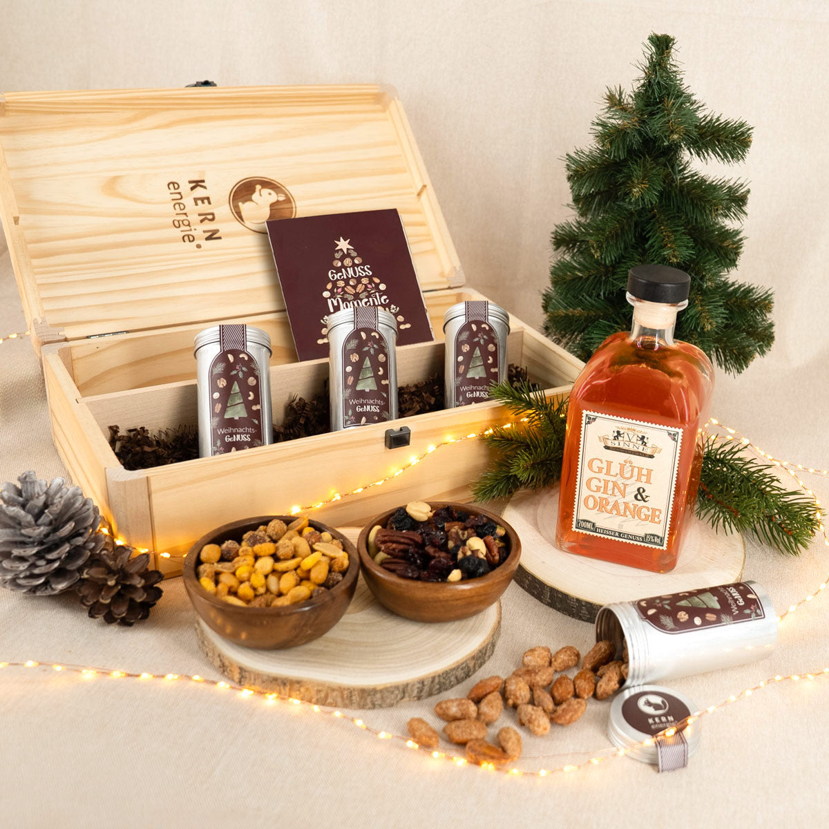 Holzbox gefüllt mit Nussmischungen, gebrannten Mandeln und Cashewkernen, sowie einem Glüh Gin