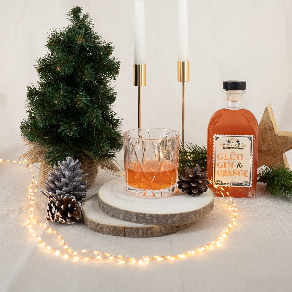 Befülltes Gin Glas mit Glüh Gin und dazugehöriger Gin Flasche und weihnachtlicher Dekoration