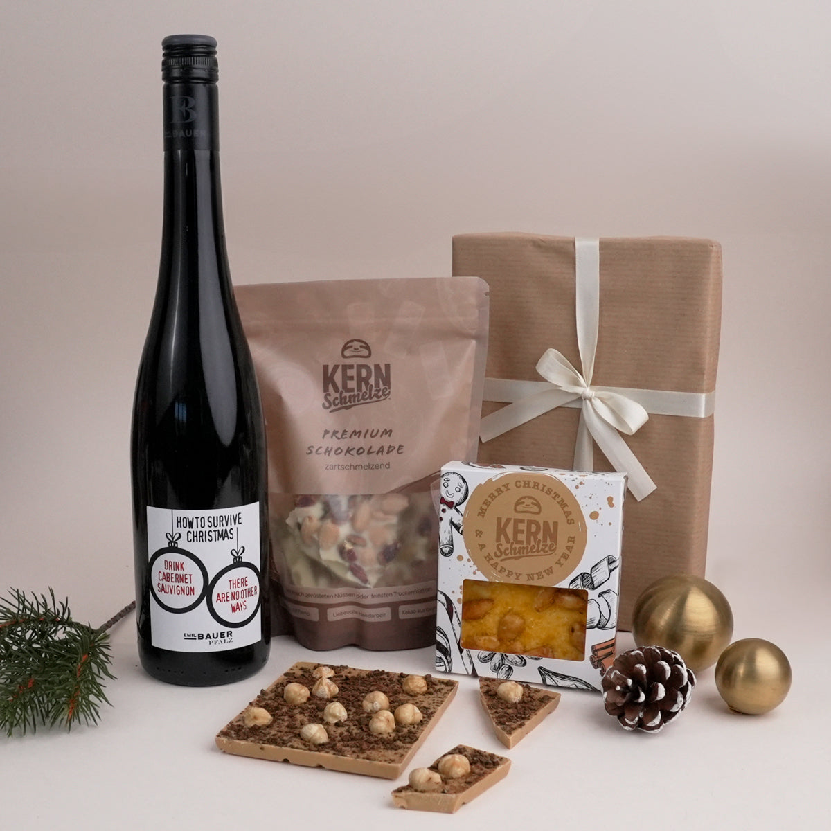 Rotwein und Schokostücke und -Tafeln in weihnachtlicher Verpackung