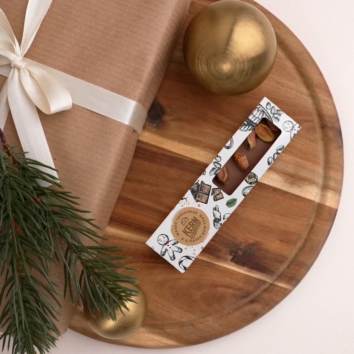 Schokoladenriegel mit Vollmilchschokolade und Pistazien in weihnachtlicher Verpackung