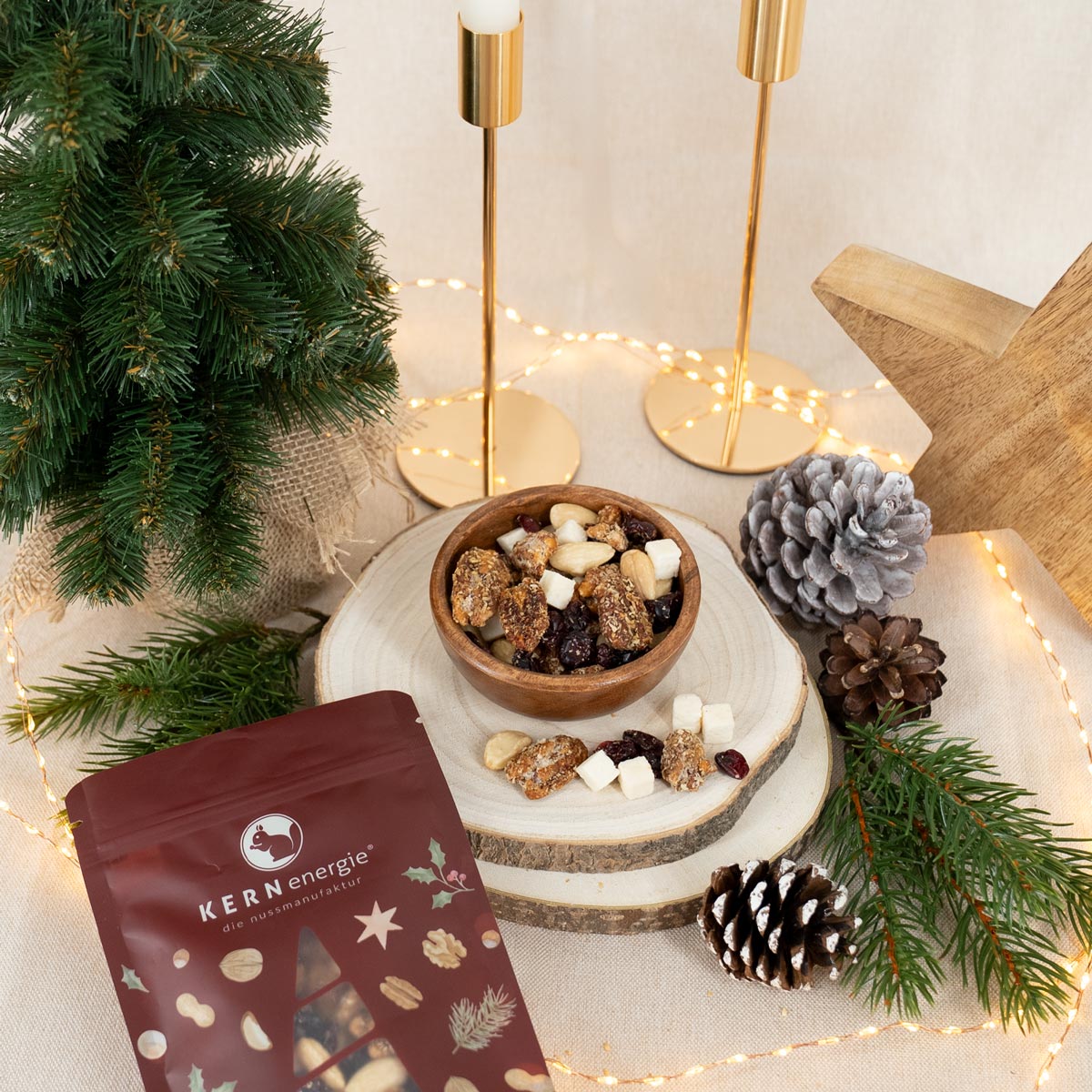 Nuss-Frucht-Mischung in Holzschale und mit weihnachtlichem Snackbeutel