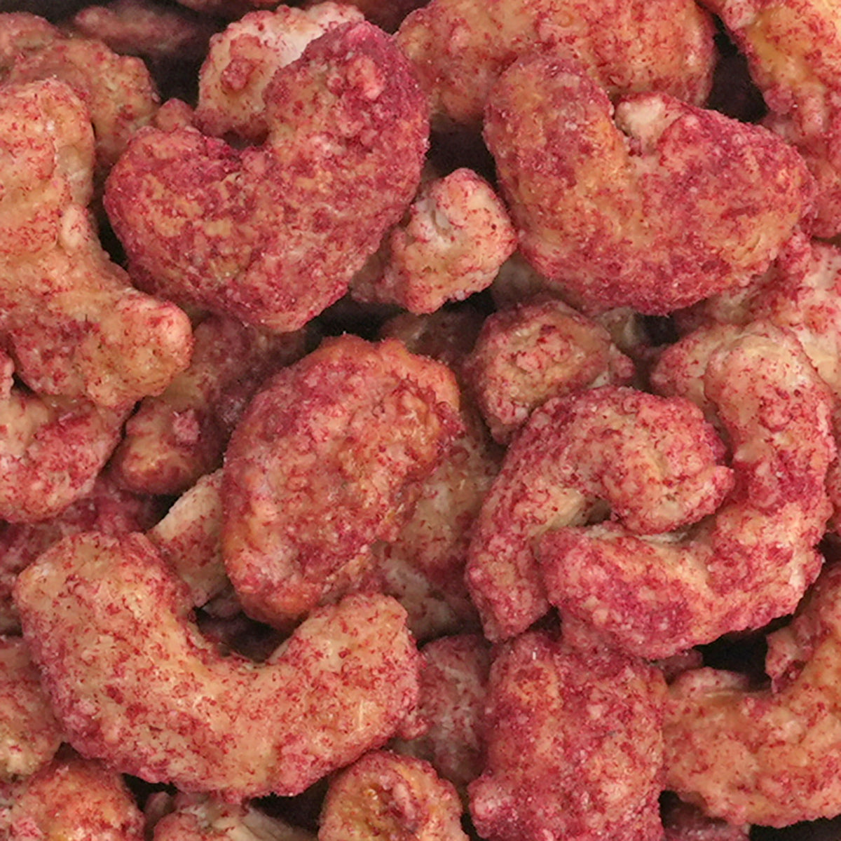 Nahaufnahme Sweet Berry Cashews, gebrannten Cashews mit fruchtig-sauren gefriergetrockneten Himbeerstaub