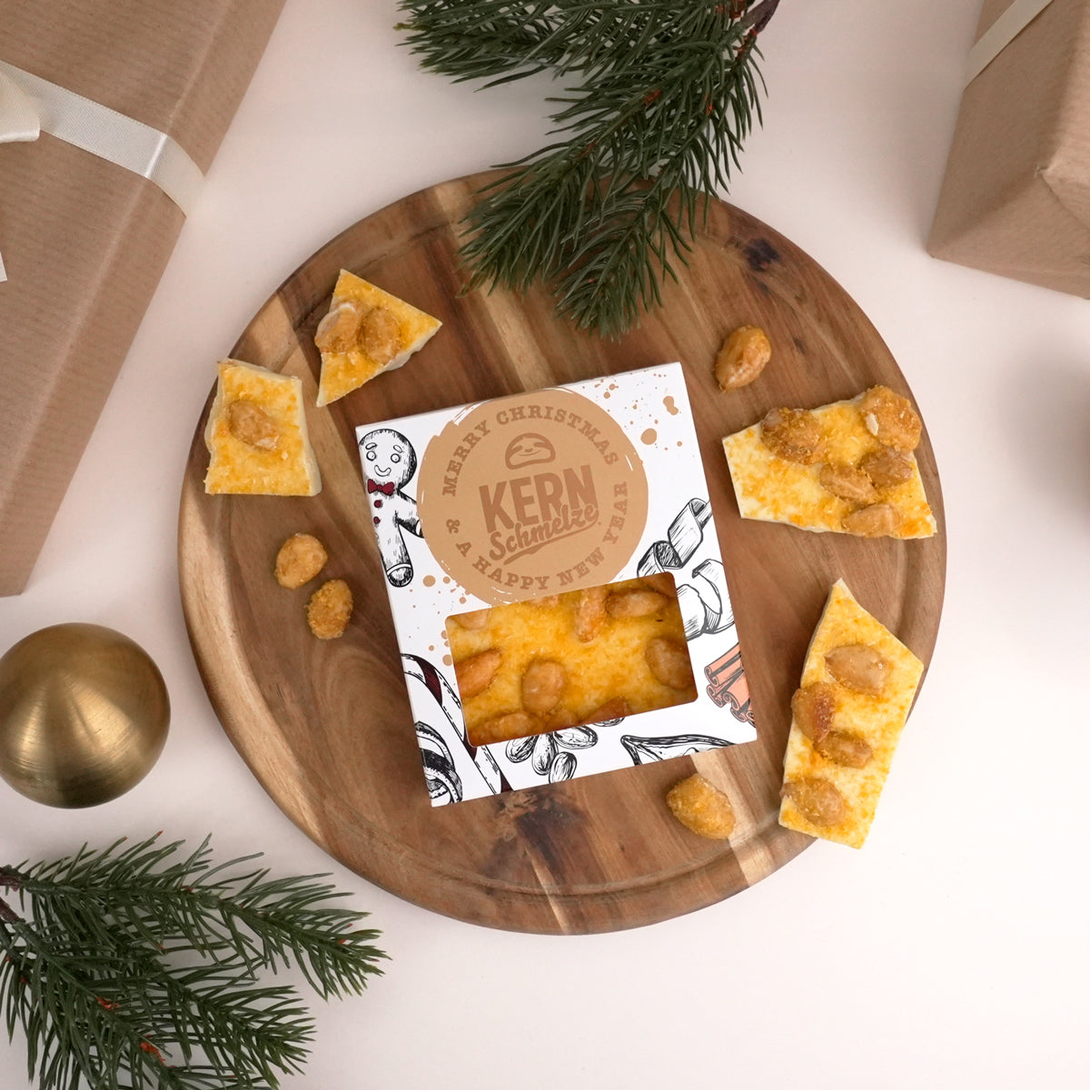 Schokoladentafel weißer Schokolade, gebrannten Mandeln und Mandarine in weihnachtlicher Verpackung