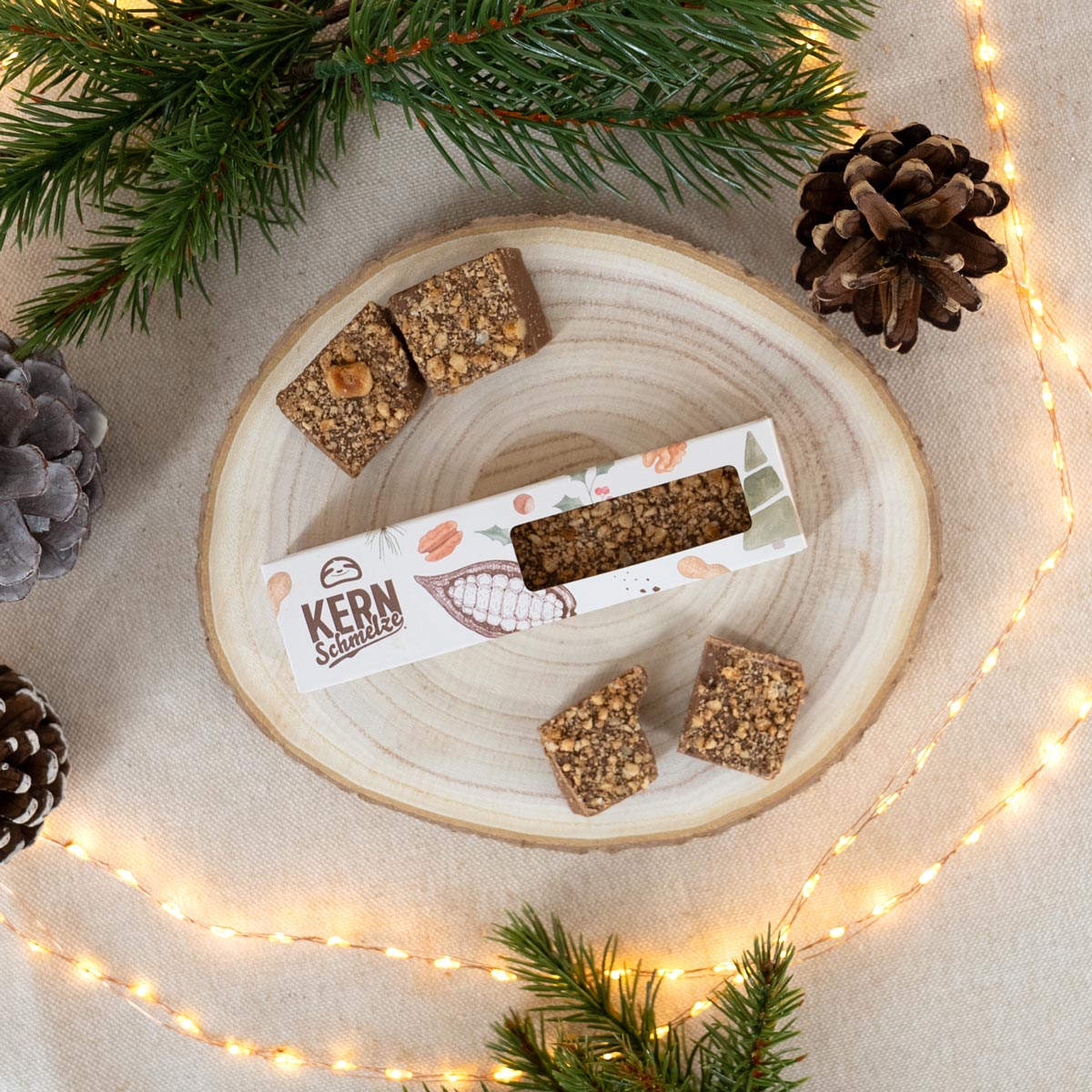 Schokoladenriegel aus Vollmilchschokolade und Haselnussstücken in weihnachtlicher Verpackung