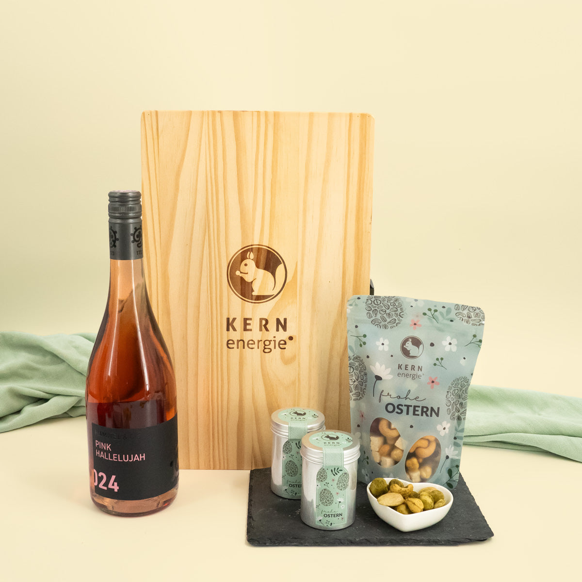 präsentierung von Flasche Roséwein und Holzbox, sowie Snack Beutel und Aludosen mit Oster Aufdruck