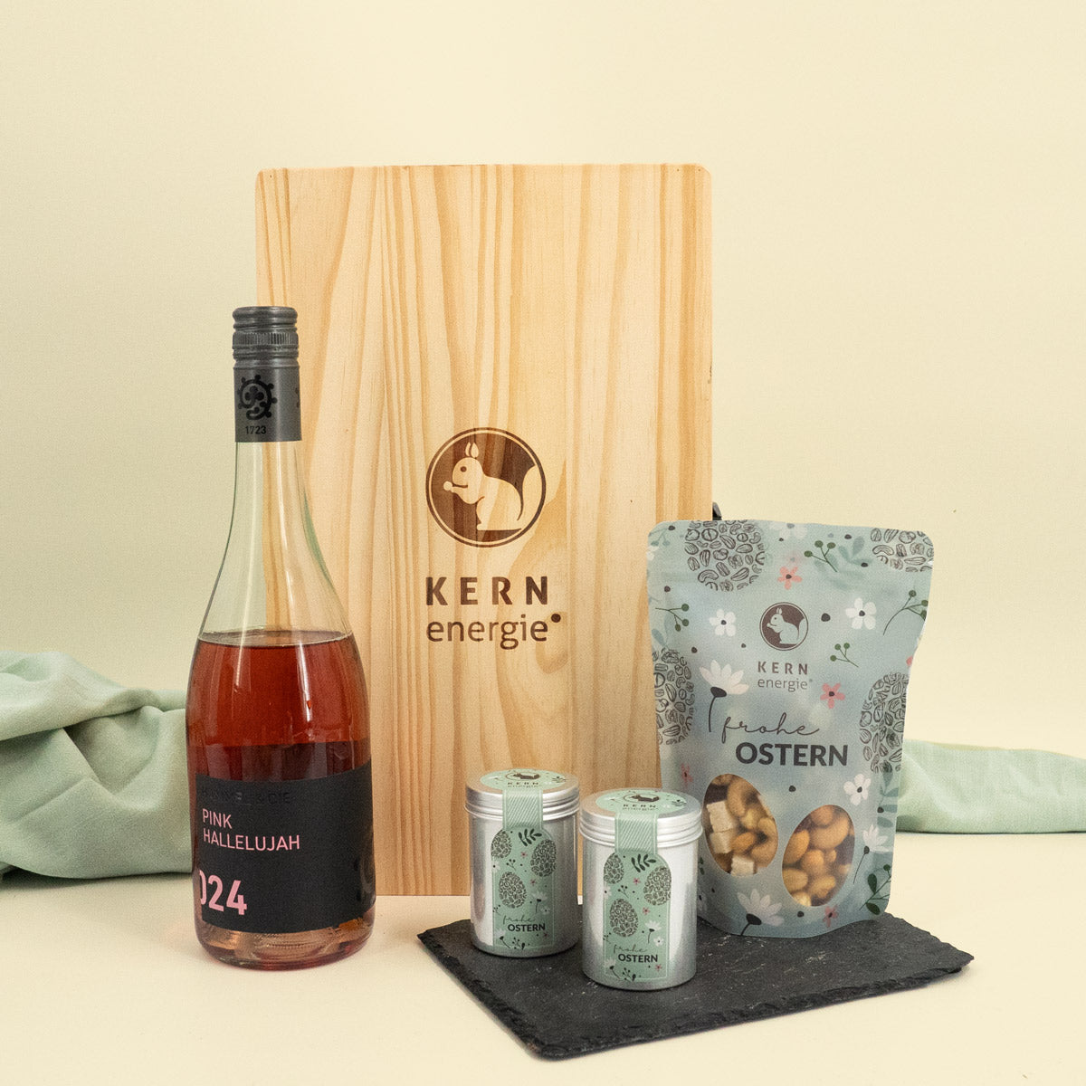 Präsentierung mit Flasche Roséwein und Holzbox, sowie Oster Snack Beutel mit Aludosen