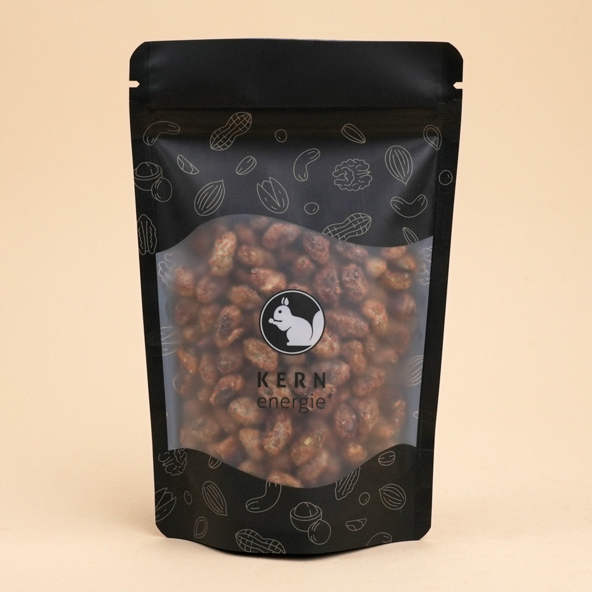 Schwarzer Snack Beutel mit Nüssen und Kernenergie Logo gefüllt mit gebrannten Pistazien