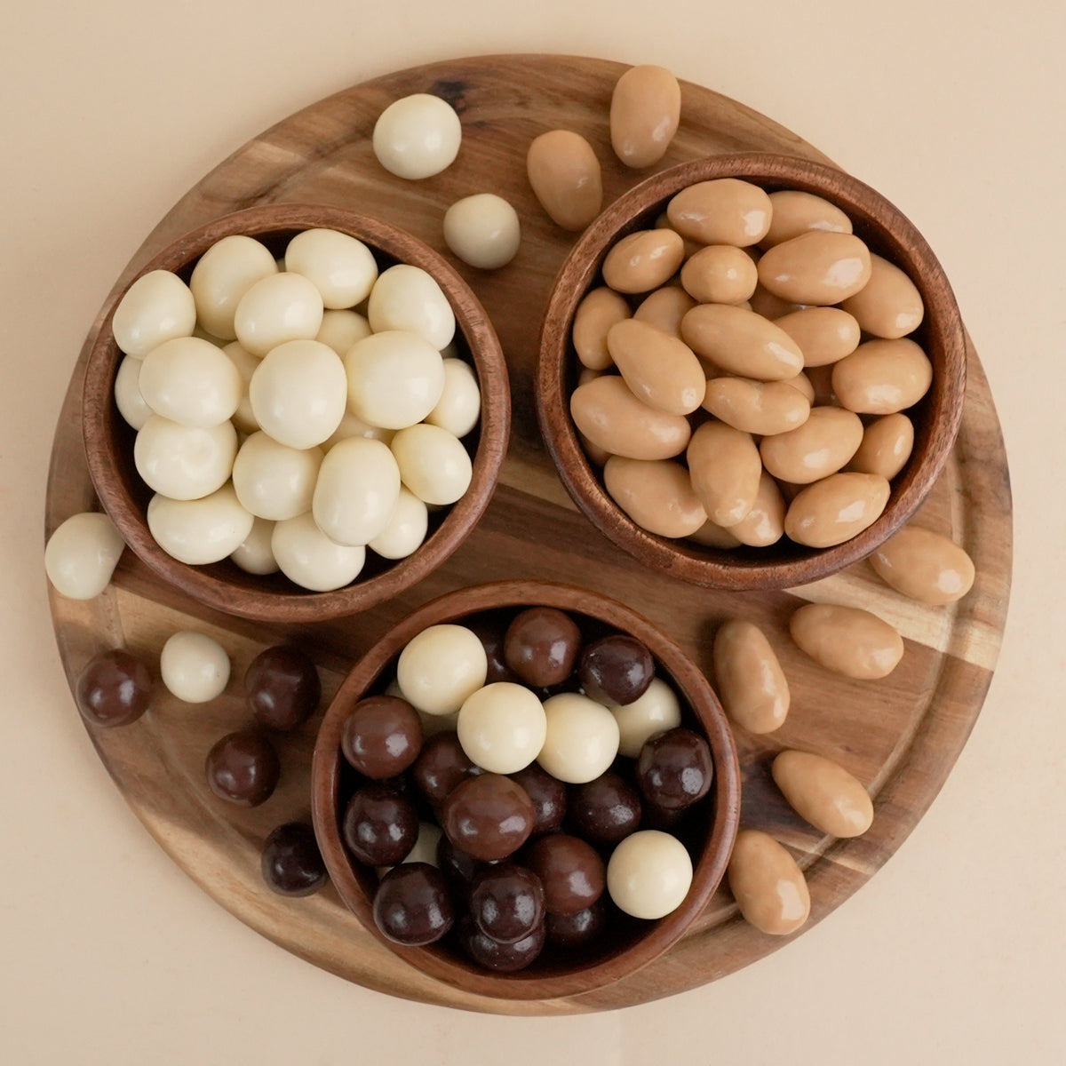 Draufsicht auf drei Schälchen mit schooladenüberzogenen Nüssen und Beeren von KRNenergie