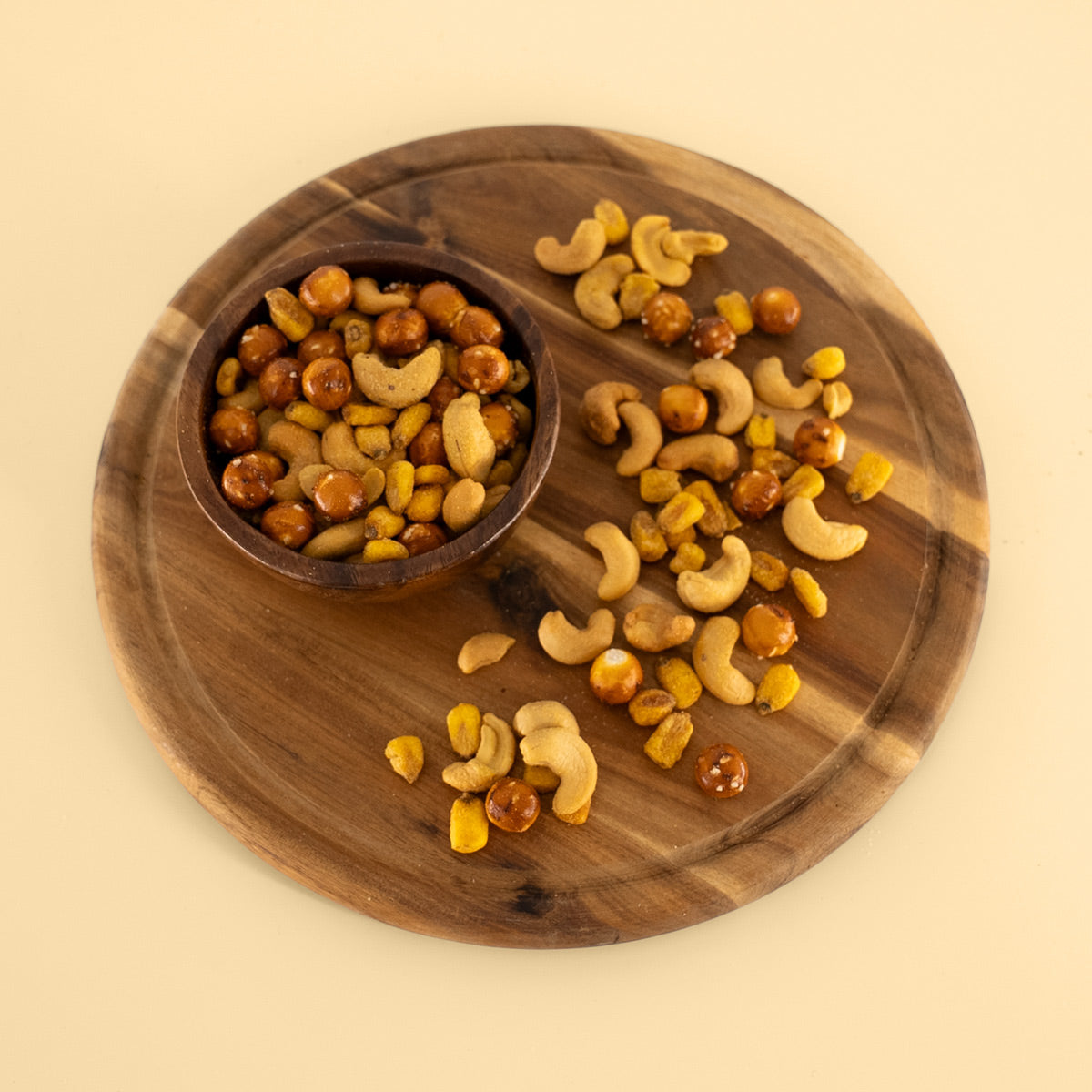 Snack Mix mit gerösteten Cashewkernen, geröstetem BBQ Mais und Brezel Balls in Holzschale arrangiert